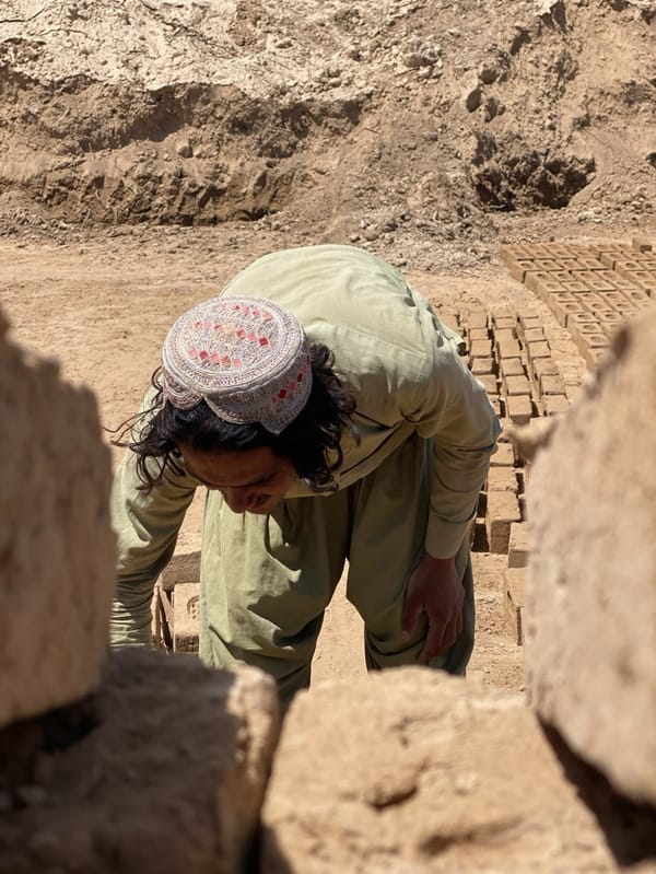 Traditional worker handles bricks in sunny Kandahar morning