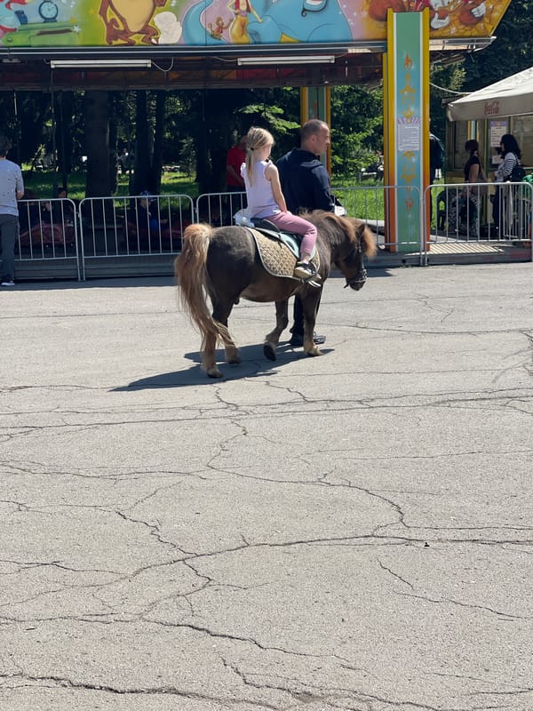 Family enjoys morning amusement park visit with poodle in Sofia