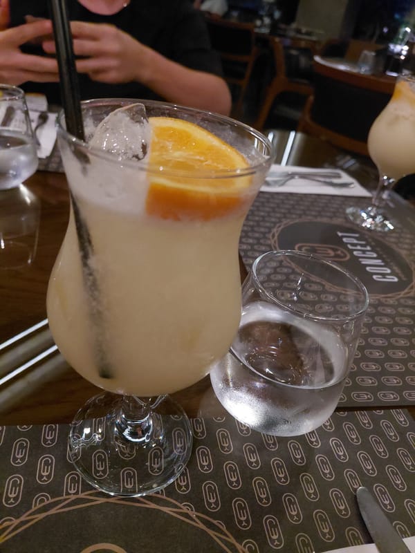 Woman documents evening restaurant meal with drinks and dessert