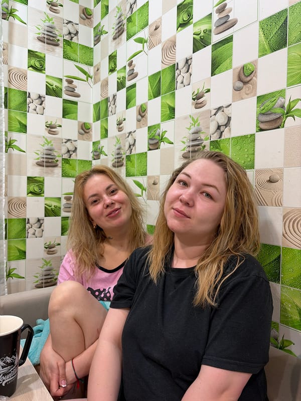 Two women photographed against decorative wall in Noviy, Russia