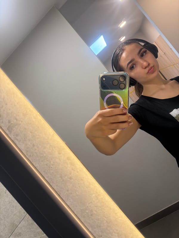 Woman takes mirror selfie with headphones in Sofia interior