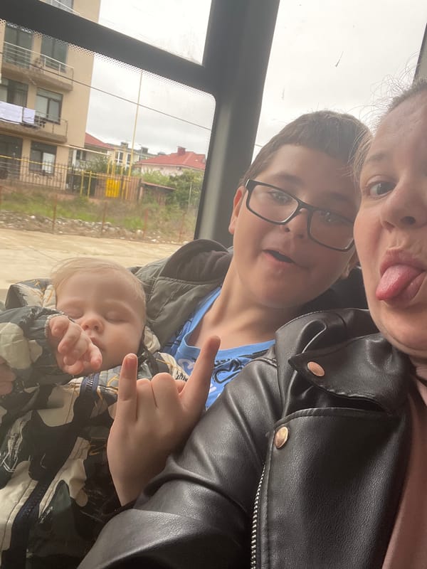 Adult holds sleeping child during vehicle journey in Russia