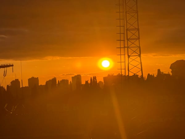 Orange sunset silhouettes Sochi's skyline at dusk