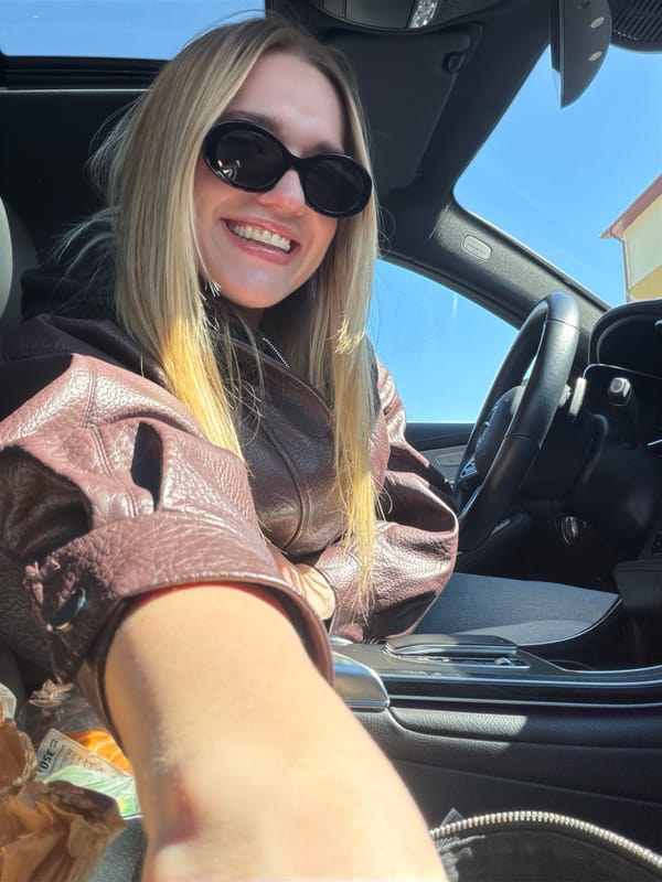 Woman takes cheerful car selfies in Ulbroka, Latvia