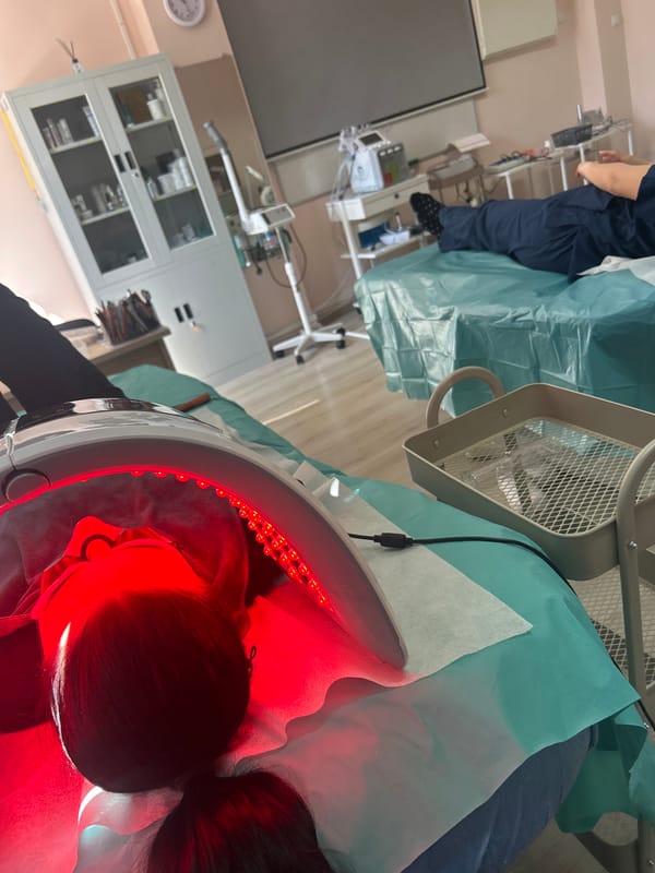 Person receives red light therapy treatment under dome device