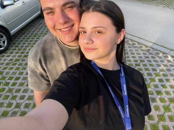 Two youth take sideways selfie on pavement in Pleven