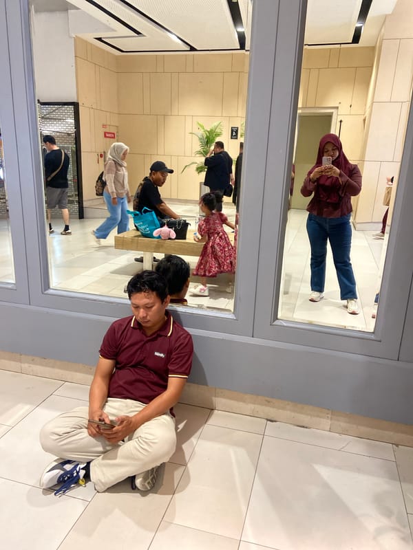Man uses smartphone while sitting on floor in Surabaya