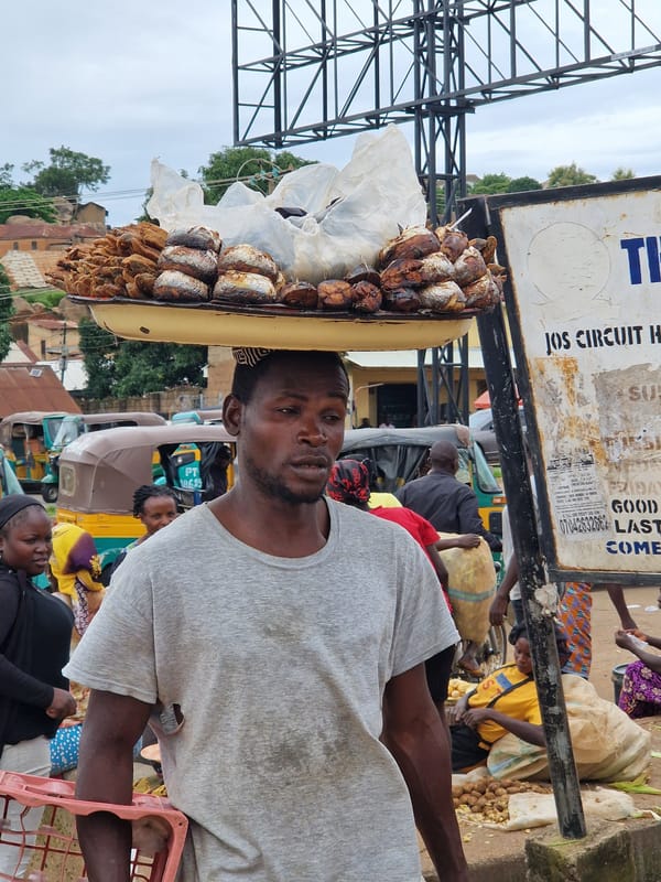 Street market hustle with head-carried goods and everyday movement