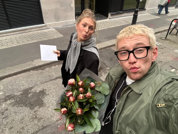 Two people with flowers and envelope observed on London street