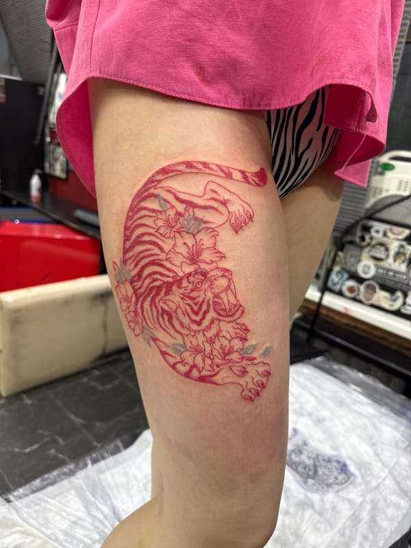 Fresh tattoo displayed on thigh in Moscow indoor setting