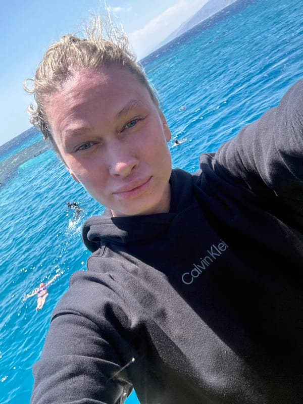 Tourist takes selfie at Dahab beach with snorkelers visible