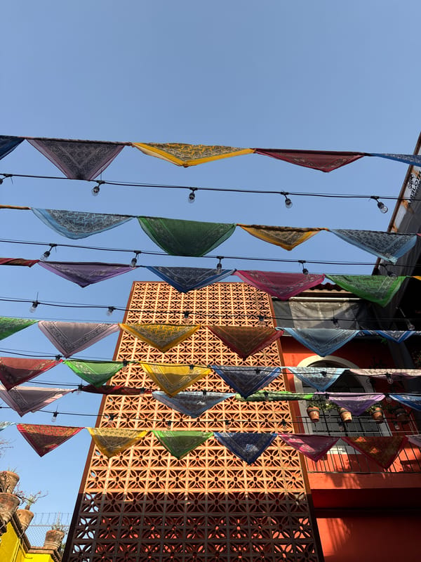 Colorful triangular flags captured hanging from lights in Puebla