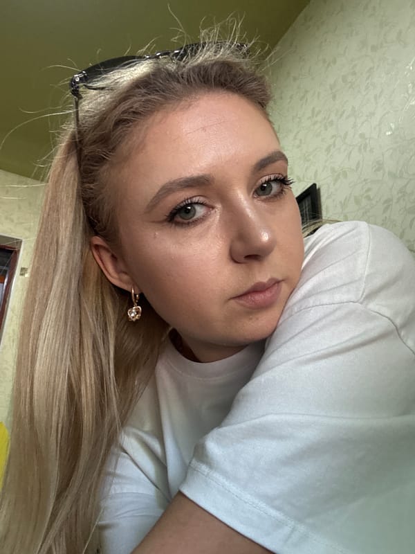 Selfie session indoors, white tee and gold jewelry throughout