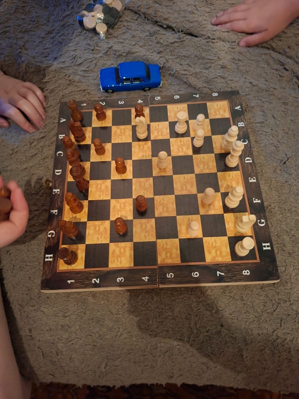 Chess game in progress on carpet, multiple players observed