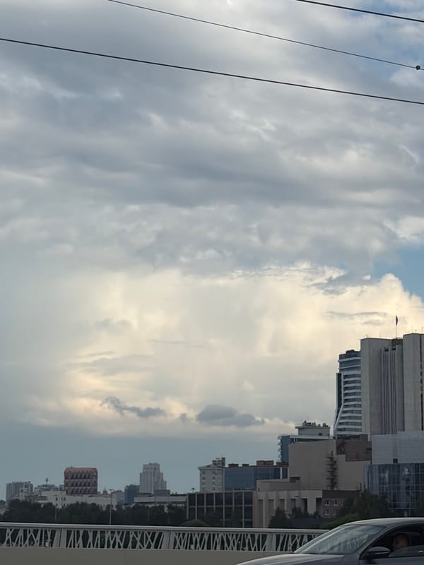 Yekaterinburg skyline under clouds, glass towers and street fence