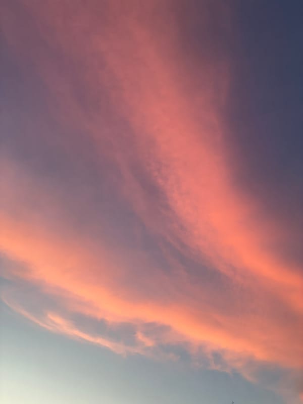 Dramatic sunset sky over a curving dusk road