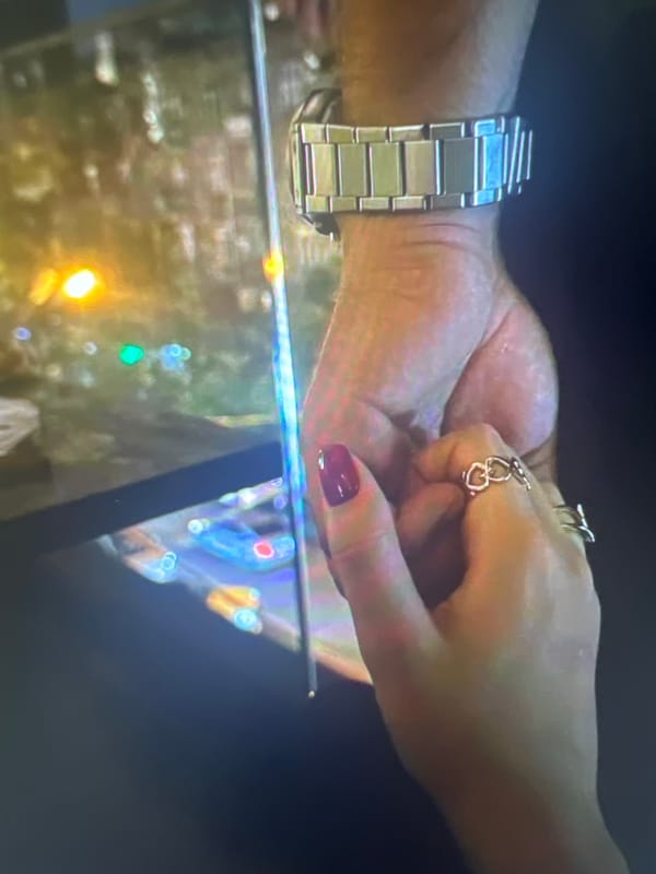 Hands holding and a betta fish drifting in a tank