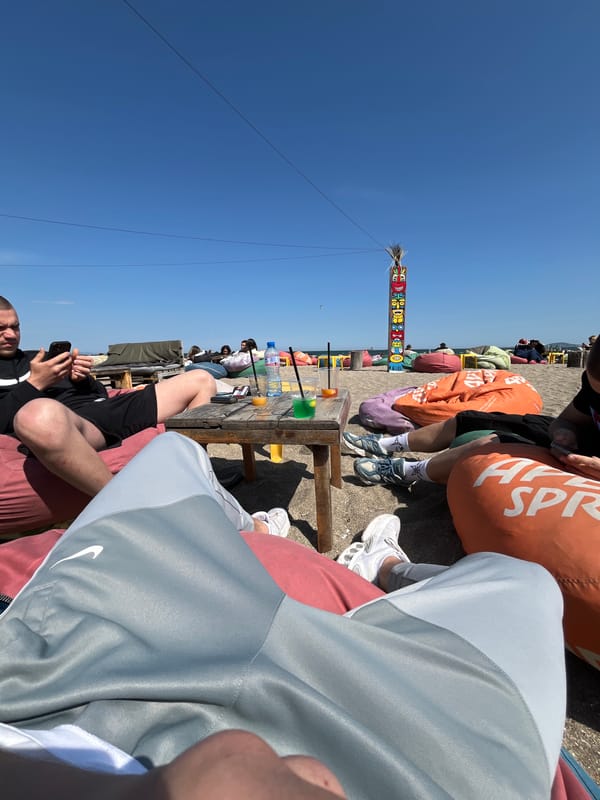 Person relaxes with smartphone at sunny Burgas beachside cafe
