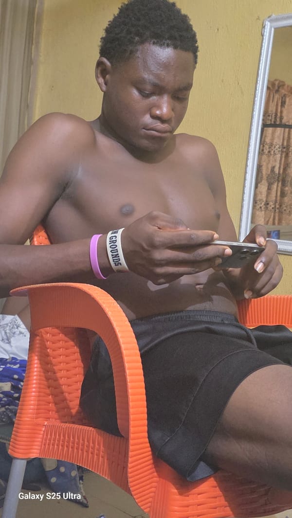 Man relaxes with smartphone in orange chair in Okada