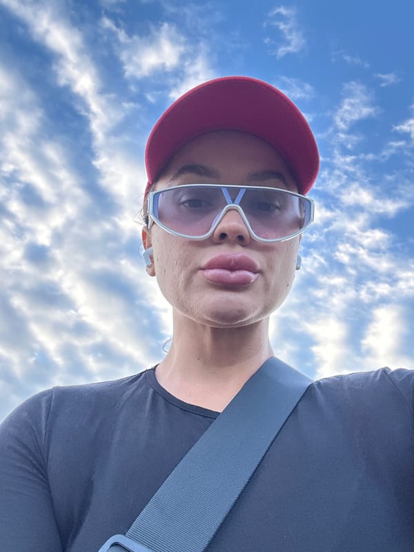 Woman takes selfie outdoors in Yuzhnouralsk wearing red cap