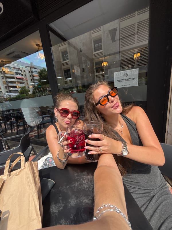Women pose at outdoor Madrid bar table