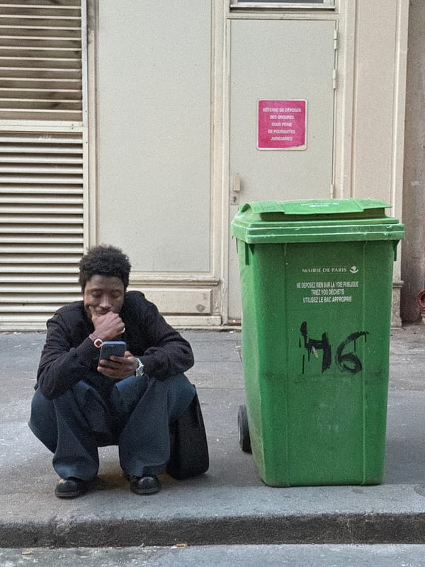 Two men in corporate polo shirts reflected in Paris shop window