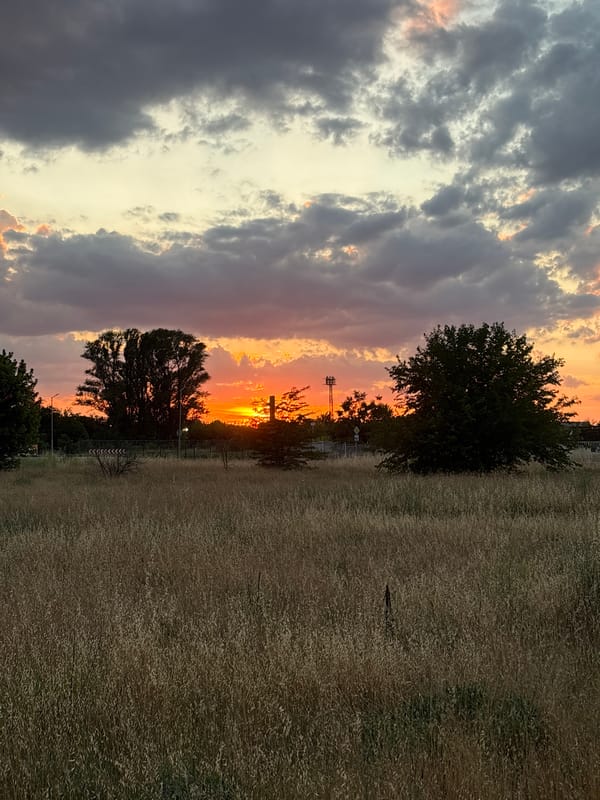 Sunset over dry fields and industrial silhouettes in Stamboliyski