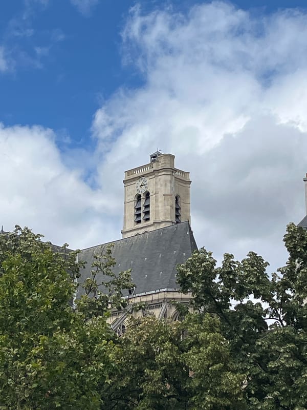 Gothic church tower and busy street life in central Paris