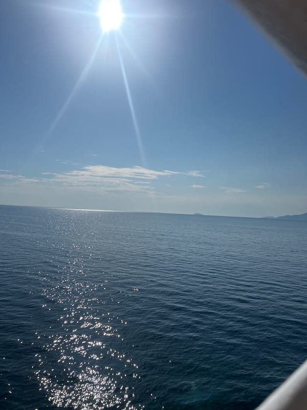 Ferry crossing open ocean on a bright, calm morning