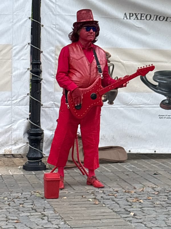 Red rocker, gold statue, and chef figure on cobblestone