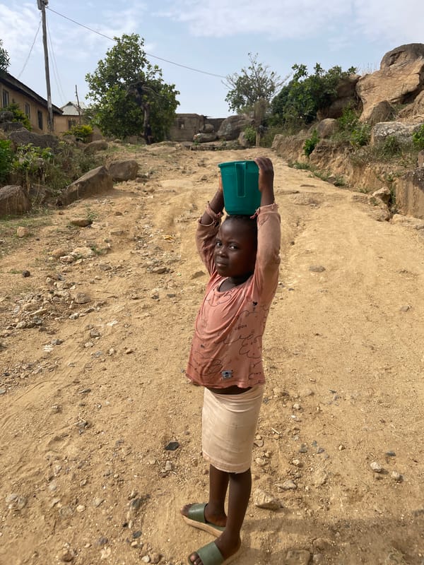 People carry loads along dusty Rukuba Road, Nigeria