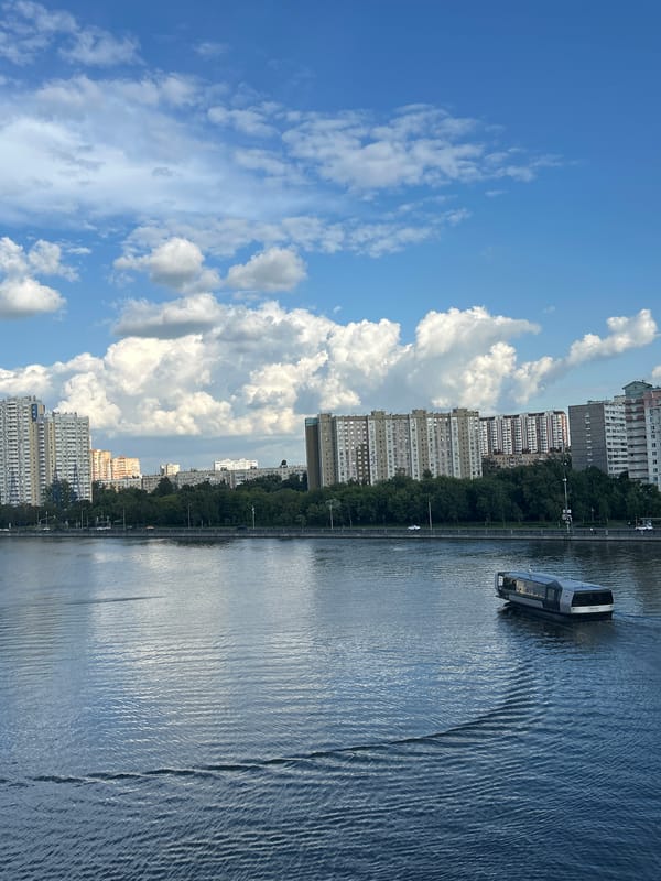 Riverside urban district: modern buildings, river traffic, and construction