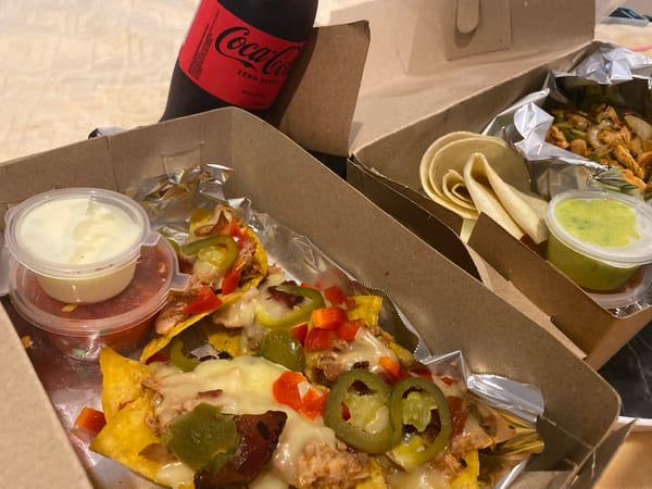 Indonesian diner documents takeout nacho meal with beverages