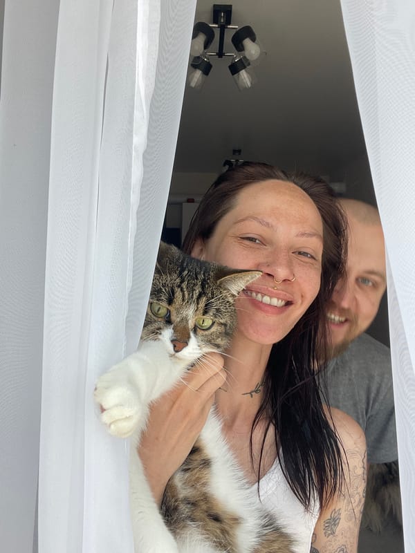 Woman, man and cat pose behind curtain in Izhevsk