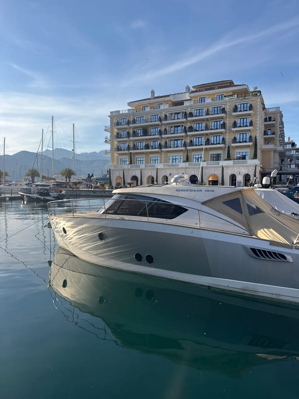Luxury yachts docked at Tivat marina on sunny afternoon