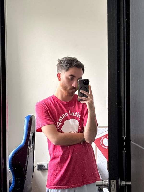 Man takes bathroom selfie with bass guitar visible in background