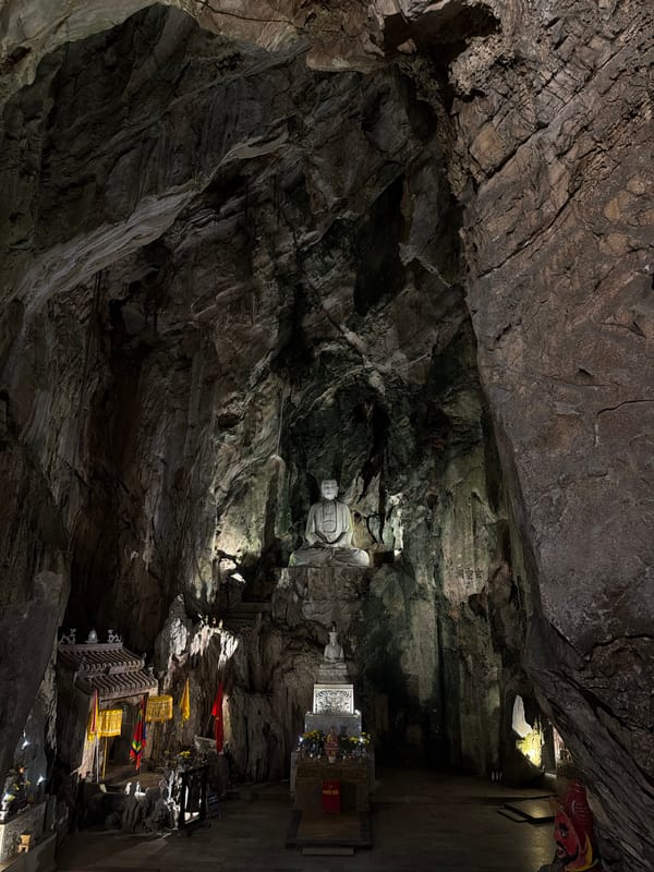 Cave temple with illuminated Buddha statue documented in Đà Nẵng