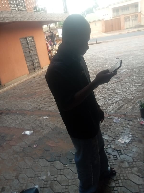 Person uses mobile phone on street in Nkpor, Nigeria
