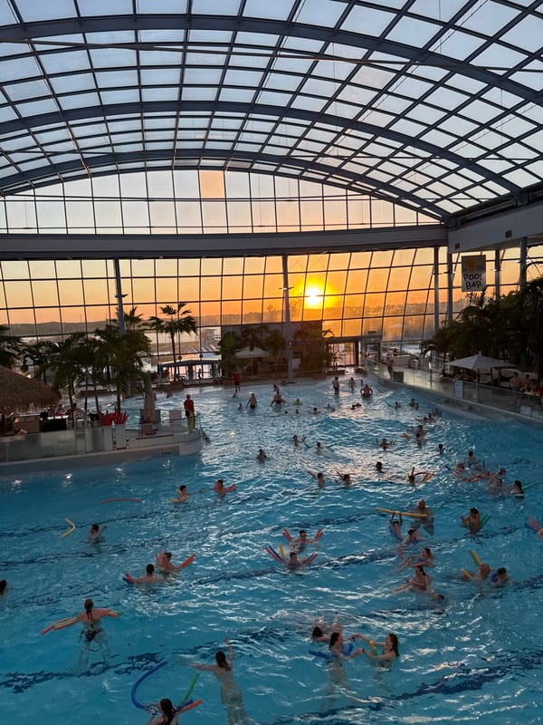 Evening crowd enjoys indoor waterpark with sunset views