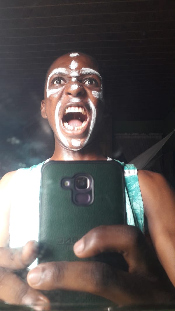 Person documents selfie session with ceremonial face paint in Nigeria