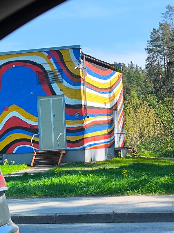 Colorful striped mural spotted on utility building in Riga