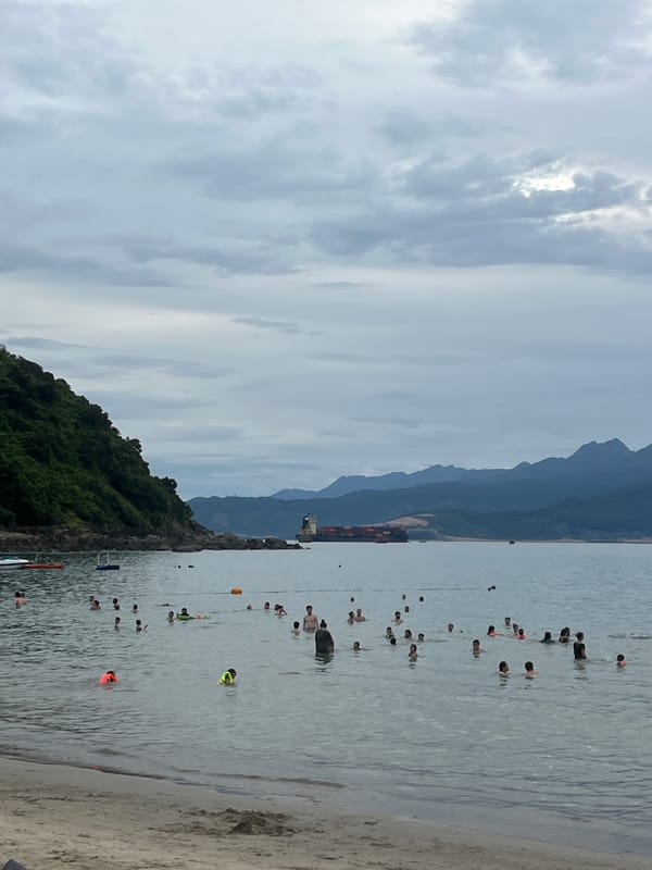 Crowded beach day in Đà Nẵng under an overcast sky
