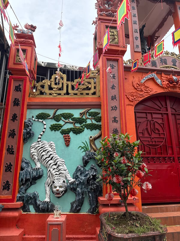 Temple gates and a coffee shop on the same Hanoi street