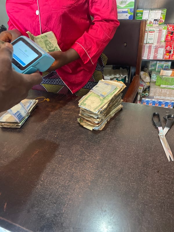 Person counts large sum of Naira currency at Nigerian shop