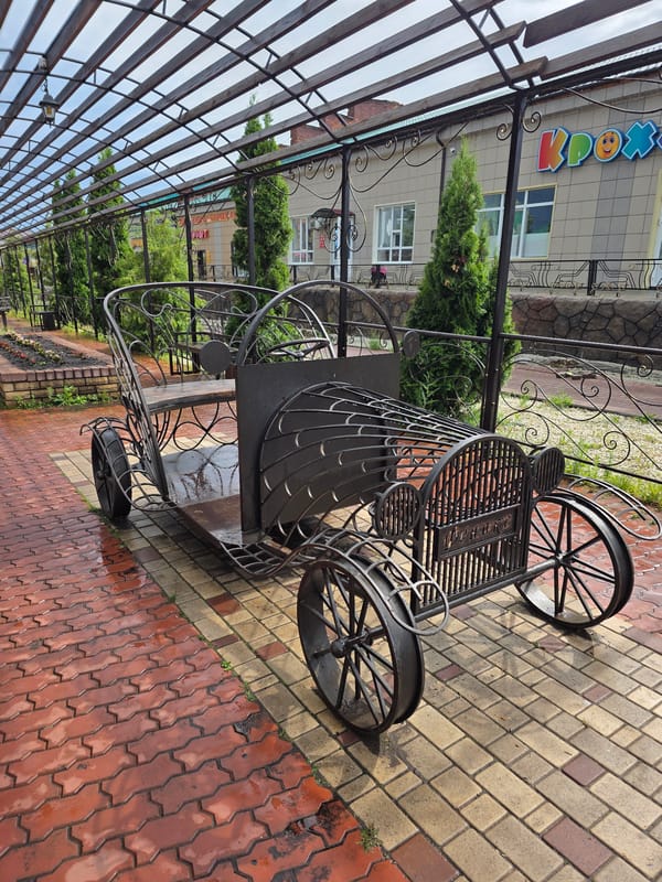 Rainy day on an ornate boulevard with sculptures and golden statues