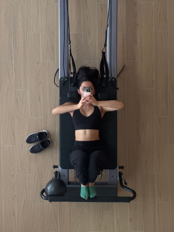 Woman multitasks with phone during home Pilates workout session