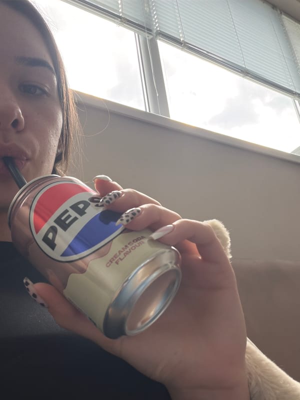Person enjoys Pepsi drink with cat companion in Dobrich