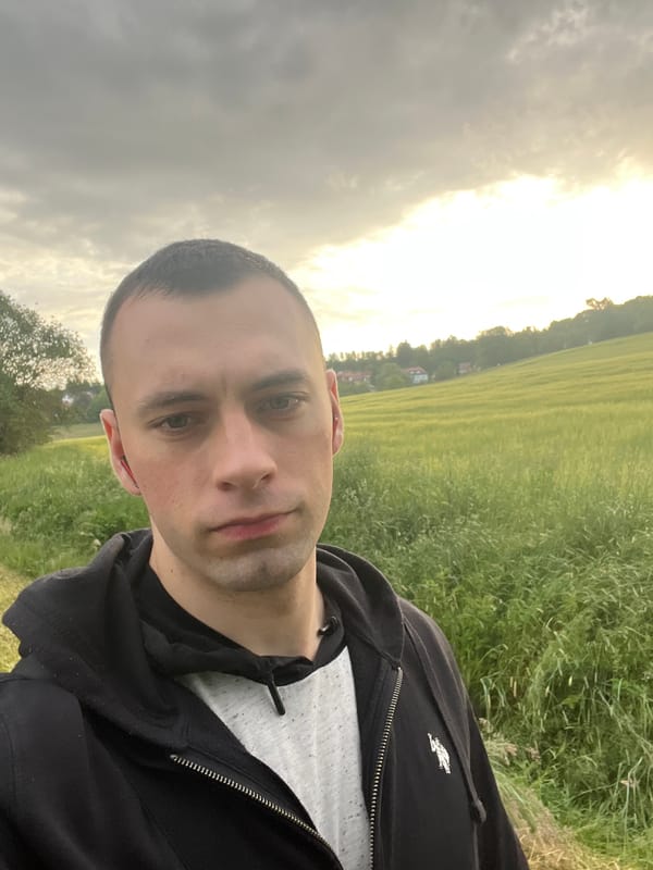 Man takes selfies in rural field under cloudy morning sky