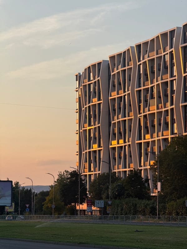 Burgas evening: angular architecture, a passing flight, dusk streets