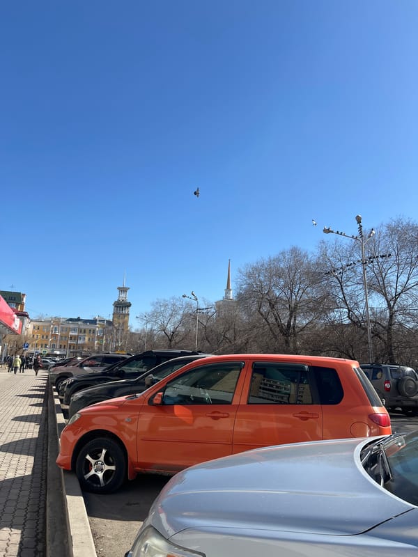 Morning street scene shows parked cars in Krasnoyarsk